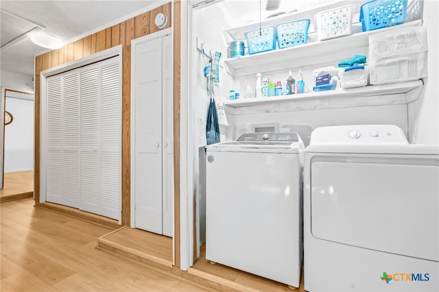 laundry area featuring hardwood / wood-style flooring, wooden walls, and independent washer and dryer