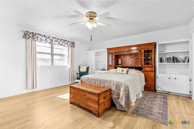 bedroom featuring ceiling fan, a textured ceiling, and light hardwood / wood-style flooring