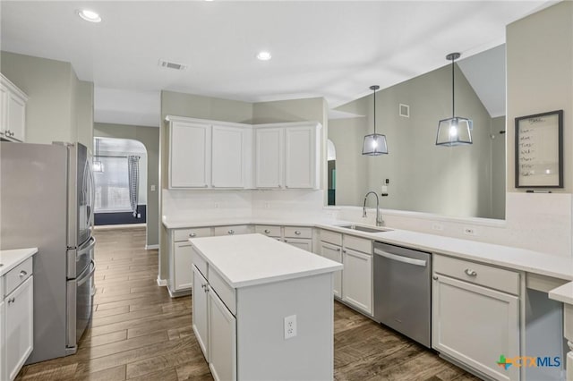 2604 Whitehurst Dr, Round Rock, TX 78681 - kitchen featuring appliances with stainless steel finishes, dark wood-style floors, a kitchen island, light countertops, and recessed lighting