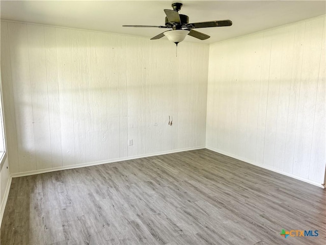 7260 Fm 531, Hallettsville, TX 77964 - unfurnished room featuring wood finished floors, a ceiling fan, wood walls, and baseboards