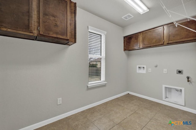 laundry area with gas dryer hookup, electric dryer hookup, hookup for a washing machine, cabinets, and light tile patterned flooring