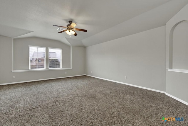 empty room featuring ceiling fan, carpet flooring, and vaulted ceiling