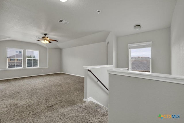 interior space with ceiling fan, carpet flooring, and vaulted ceiling