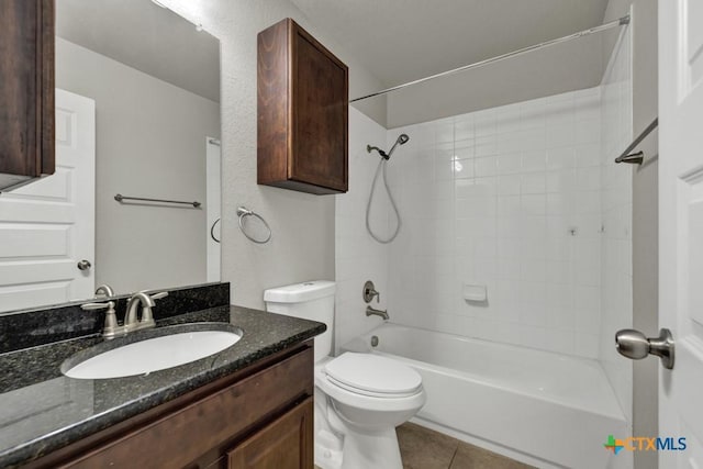 full bathroom with vanity, tiled shower / bath combo, tile patterned floors, and toilet