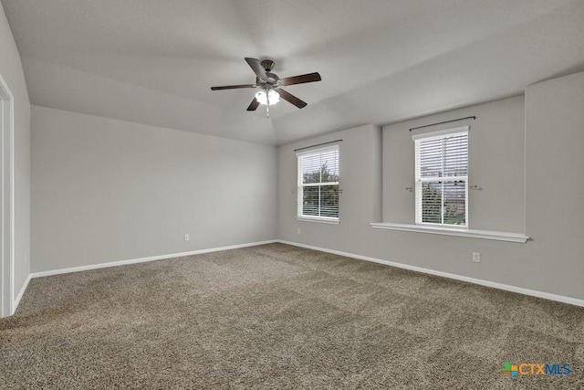 carpeted spare room with ceiling fan and vaulted ceiling