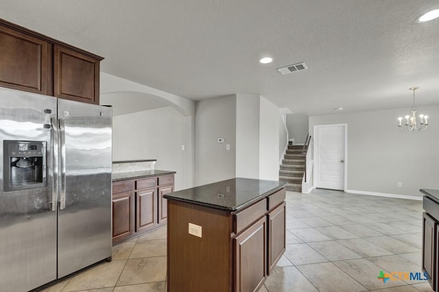 kitchen featuring pendant lighting, light tile patterned floors, stainless steel fridge, an inviting chandelier, and a center island