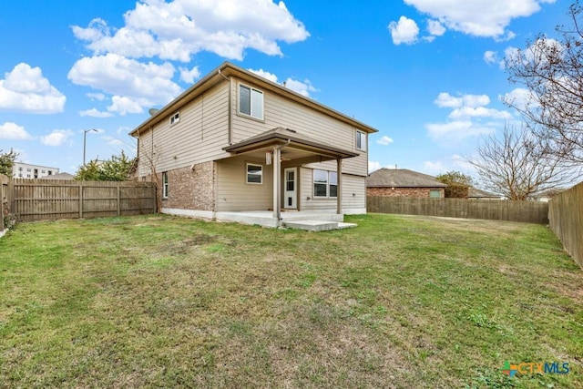 rear view of house with a patio area and a lawn