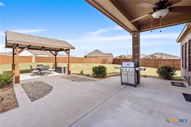 view of patio with a fenced backyard, ceiling fan, and area for grilling