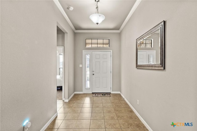 foyer with baseboards, light tile patterned floors, and crown molding