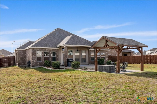 rear view of property featuring brick siding, a lawn, a gazebo, a patio area, and a fenced backyard