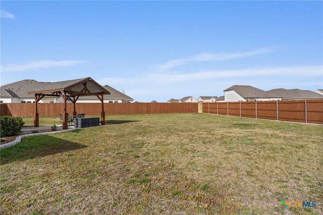 view of yard featuring central air condition unit, a fenced backyard, and a gazebo