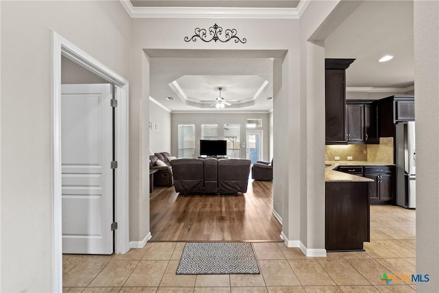 interior space with ceiling fan, crown molding, and light tile patterned floors