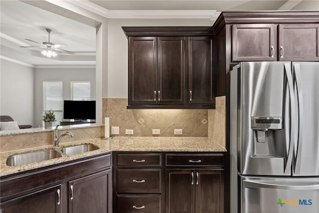 kitchen featuring ornamental molding, a sink, light stone counters, and stainless steel fridge with ice dispenser