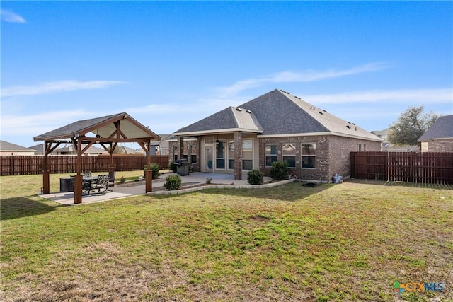 back of property with a gazebo, brick siding, a patio area, and a fenced backyard