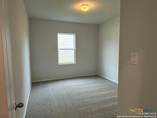 empty room with carpet flooring and a textured ceiling