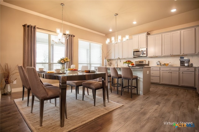 dining room with ornamental molding, dark hardwood / wood-style flooring, and a notable chandelier