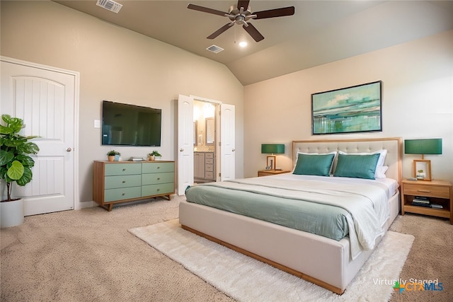 carpeted bedroom with ensuite bathroom, ceiling fan, and vaulted ceiling