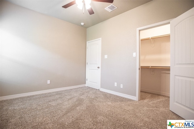 unfurnished bedroom featuring a spacious closet, ceiling fan, and carpet floors