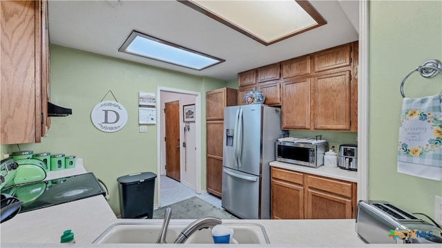 kitchen featuring stainless steel appliances, sink, and ventilation hood