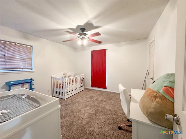 bedroom featuring carpet flooring, ceiling fan, and a crib