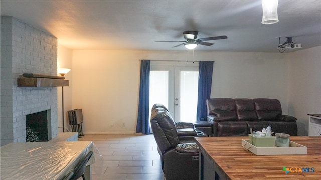 living room featuring french doors, a brick fireplace, and ceiling fan