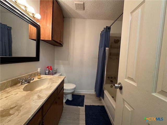 full bathroom featuring shower / bathtub combination with curtain, wood-type flooring, a textured ceiling, toilet, and vanity