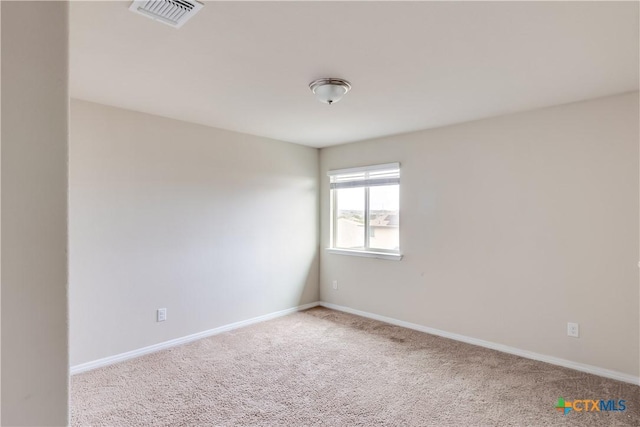 carpeted empty room featuring baseboards
