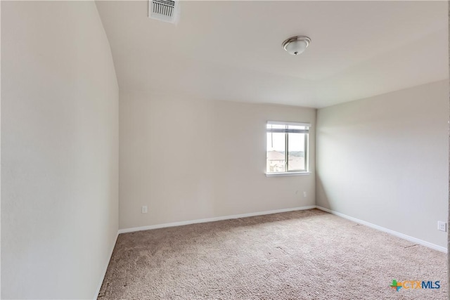 spare room featuring carpet flooring and baseboards