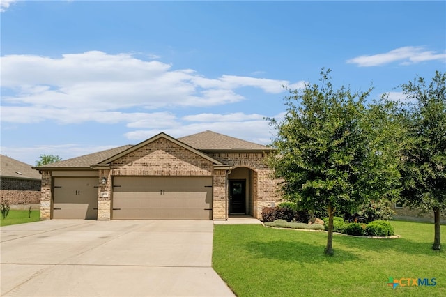 6038 Ballast Trl, New Braunfels, TX 78132 - view of front facade with an attached garage, driveway, a front yard, brick siding, and a shingled roof