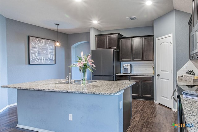 kitchen featuring appliances with stainless steel finishes, sink, dark brown cabinets, and a kitchen island with sink