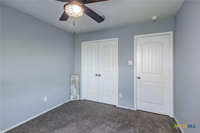 unfurnished bedroom featuring a closet, dark carpet, and ceiling fan