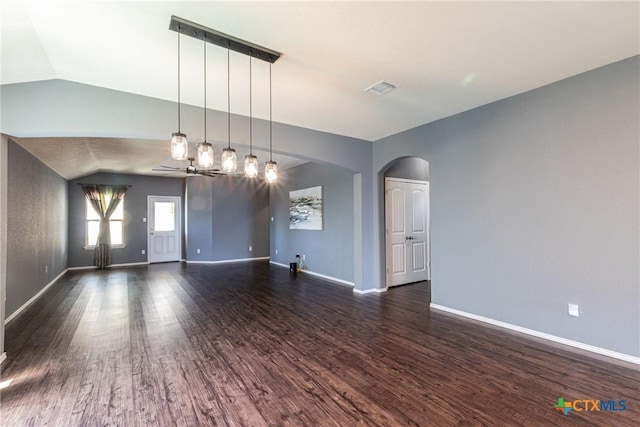 empty room with ceiling fan, lofted ceiling, and dark hardwood / wood-style flooring