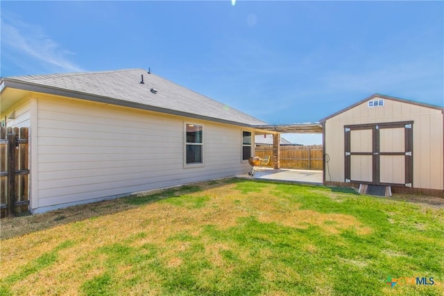 rear view of house with a patio area, a lawn, and a storage shed