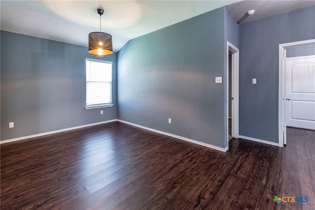 empty room with lofted ceiling and dark wood-type flooring