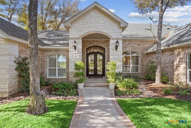 entrance to property with french doors and a yard