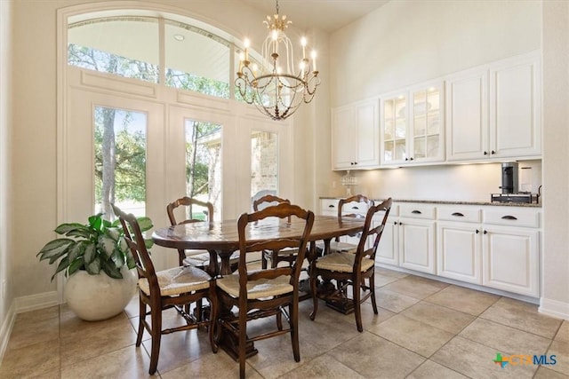 tiled dining room with a high ceiling and an inviting chandelier