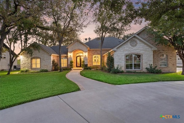 french country home featuring a front lawn