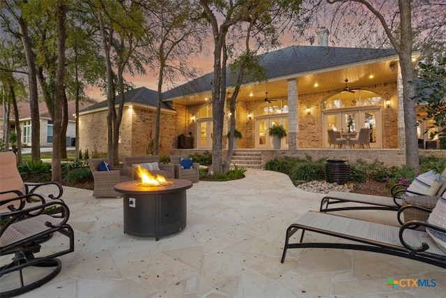 view of patio / terrace featuring a ceiling fan, french doors, and an outdoor fire pit