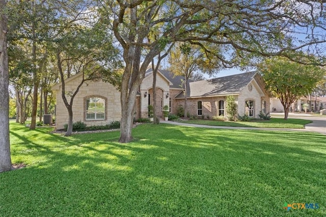 view of front of property with central air condition unit and a front lawn