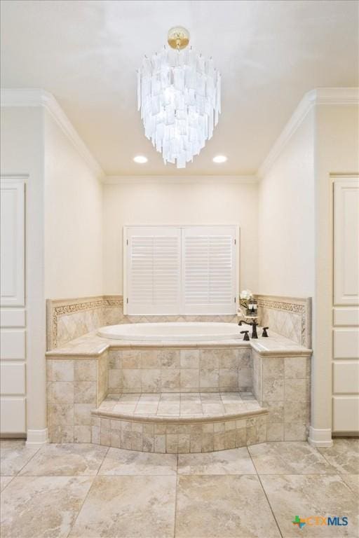 bathroom featuring ornamental molding, an inviting chandelier, and a relaxing tiled tub