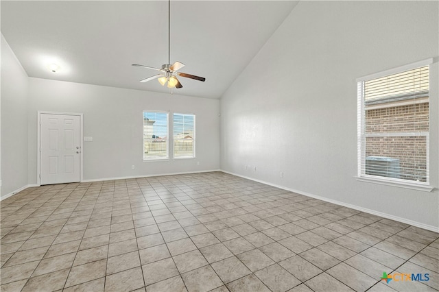 tiled spare room with ceiling fan and high vaulted ceiling