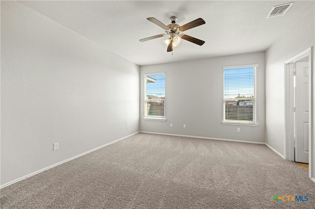 unfurnished bedroom with ceiling fan, light colored carpet, and a textured ceiling