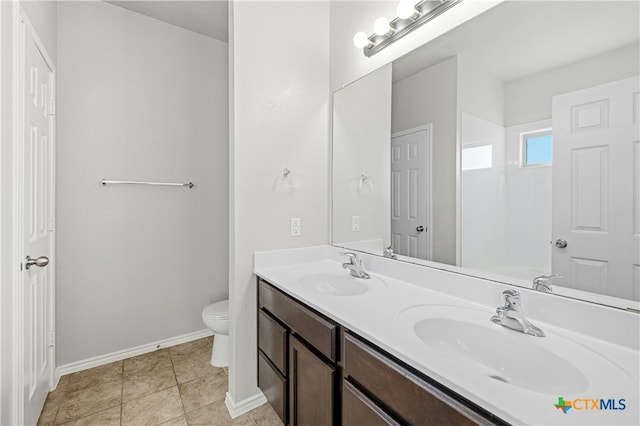 bathroom with tile patterned flooring, vanity, and toilet