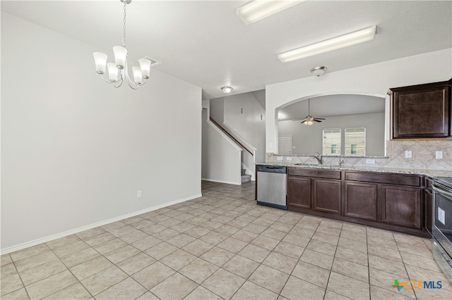 kitchen featuring dishwasher, light stone counters, sink, and ceiling fan with notable chandelier