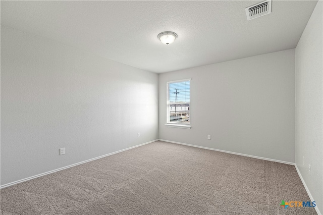 empty room featuring carpet and a textured ceiling