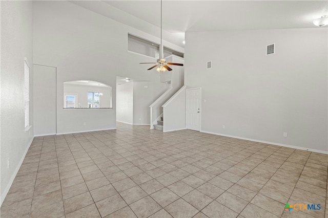 unfurnished living room featuring ceiling fan, high vaulted ceiling, and light tile patterned flooring