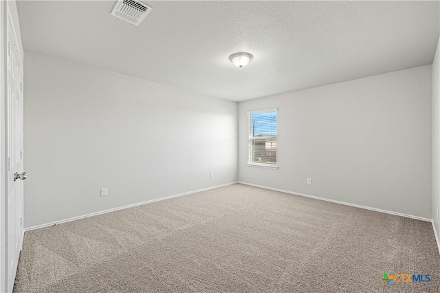 spare room featuring carpet flooring and a textured ceiling