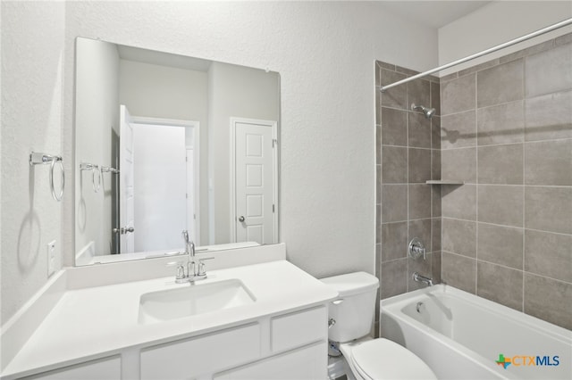 full bathroom with vanity, tiled shower / bath combo, and toilet