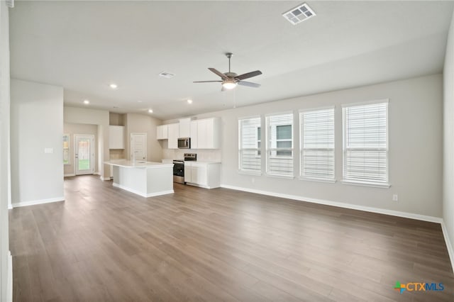 unfurnished living room featuring wood-type flooring, ceiling fan, and sink