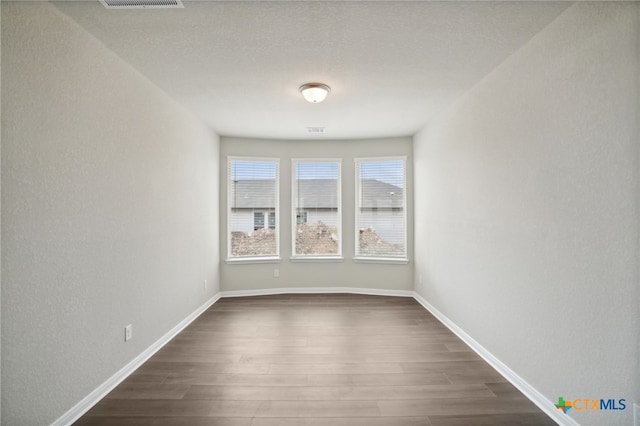 spare room with dark wood-type flooring